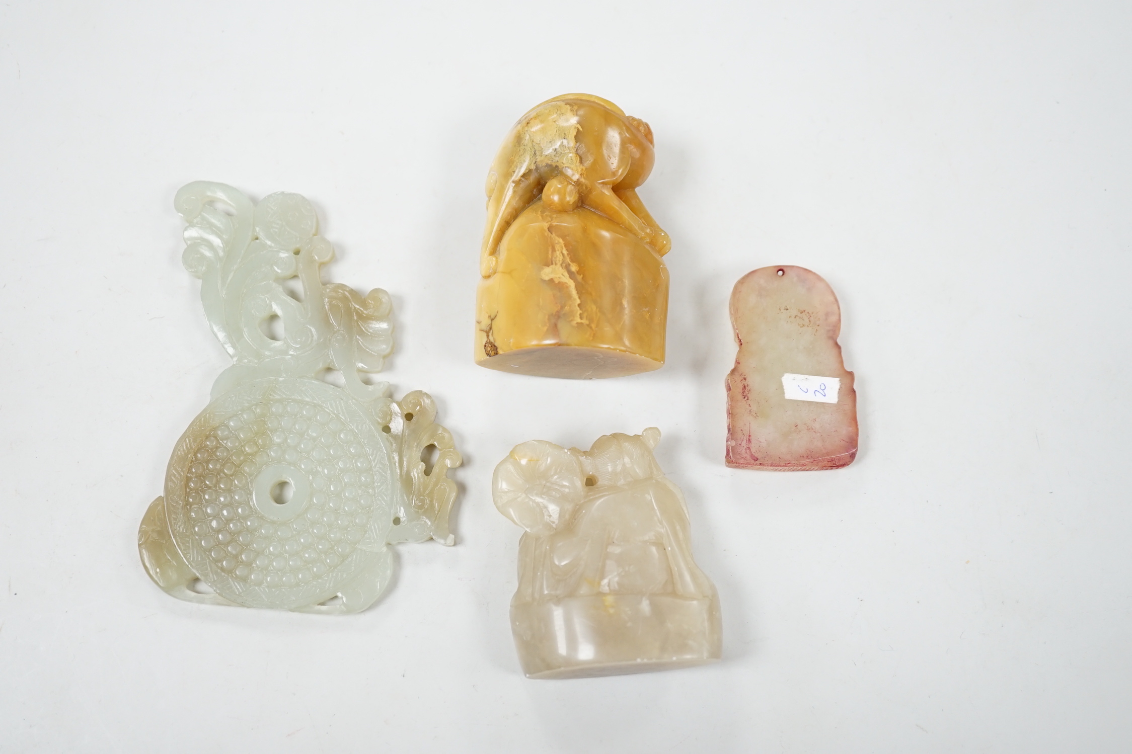 A collection of Chinese jade and soapstone carvings, largest a carved panel 11cm long